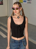 Woman wearing a black lace-trimmed tie-front cropped tank top