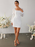 Full length view of a woman in a white sheath dress with sheer bishop sleeves.