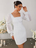 Woman smiling in a white sheath dress with sheer bishop sleeves and a square neckline.