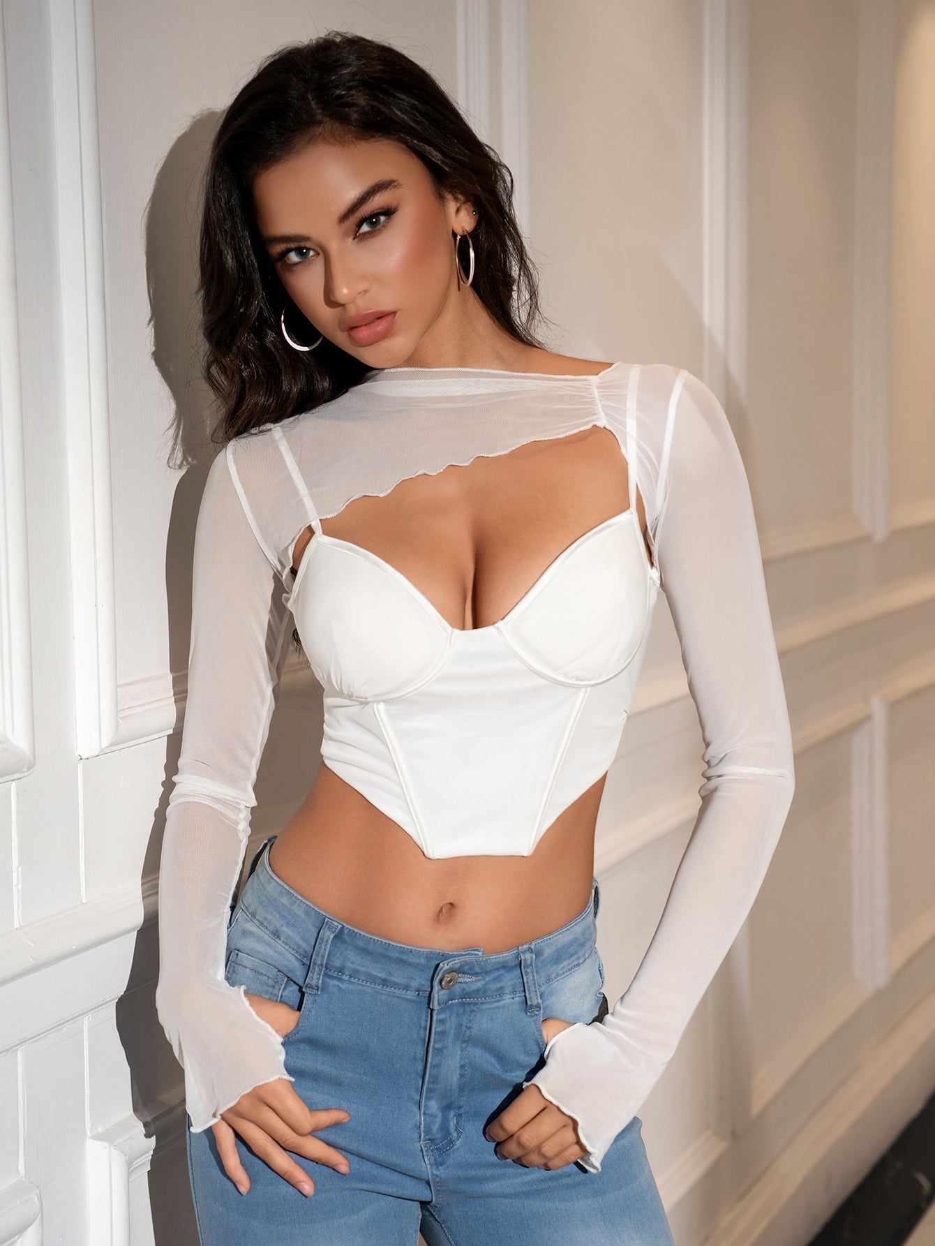 Woman wearing a white mesh overlay crop top with a sweetheart neckline and underwire bustier detail