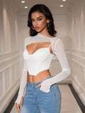 Front view of a woman in a white mesh overlay crop top with a cut-out detail and asymmetrical hem