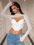 Woman posing in a white mesh overlay crop top with a sweetheart neckline and long sleeves