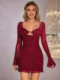 Smiling woman in a red sparkling mesh mini dress with long flared sleeves and sweetheart neckline.