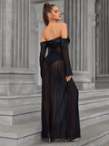 Back view of a woman in a black off-the-shoulder sheer mesh maxi dress.