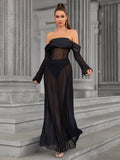 Woman walking in a black off-the-shoulder sheer mesh maxi dress.