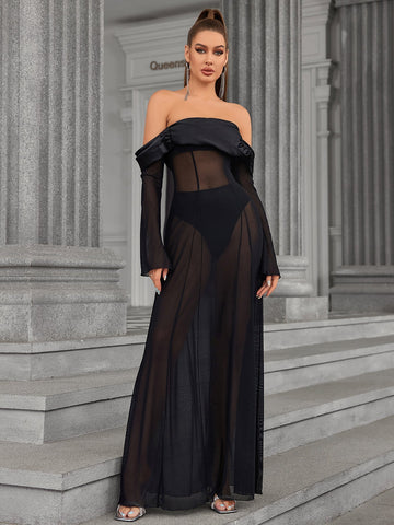 Woman wearing a black off-the-shoulder sheer mesh maxi dress with long flared sleeves.