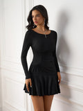 Woman posing in a black ruched side detail dress with a flared hem.