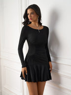 Woman posing in a black ruched side detail dress with a flared hem.