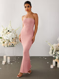 Full body shot of a woman in a pink strapless ribbed knit mermaid maxi dress