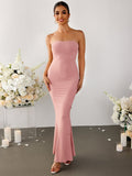 Woman smiling in a pink strapless ribbed knit mermaid maxi dress