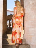 Rear view of a woman in a strapless floral print maxi dress with a flowing scarf.