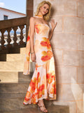Woman posing in a strapless, orange and pink floral print gown with a draped scarf.