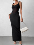 Full length view of a woman wearing a black sleeveless maxi dress with sheer bodice and slit