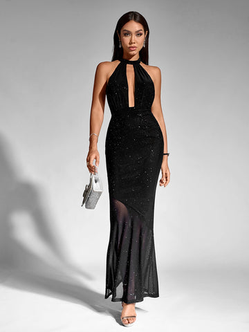 Woman in a black sparkling halter neck maxi dress with a keyhole cutout and mermaid hemline