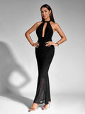 Full body shot of a woman wearing a black sparkling halter neck maxi dress