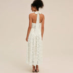 Woman wearing a white lace halter midi dress, back view showing bow detail