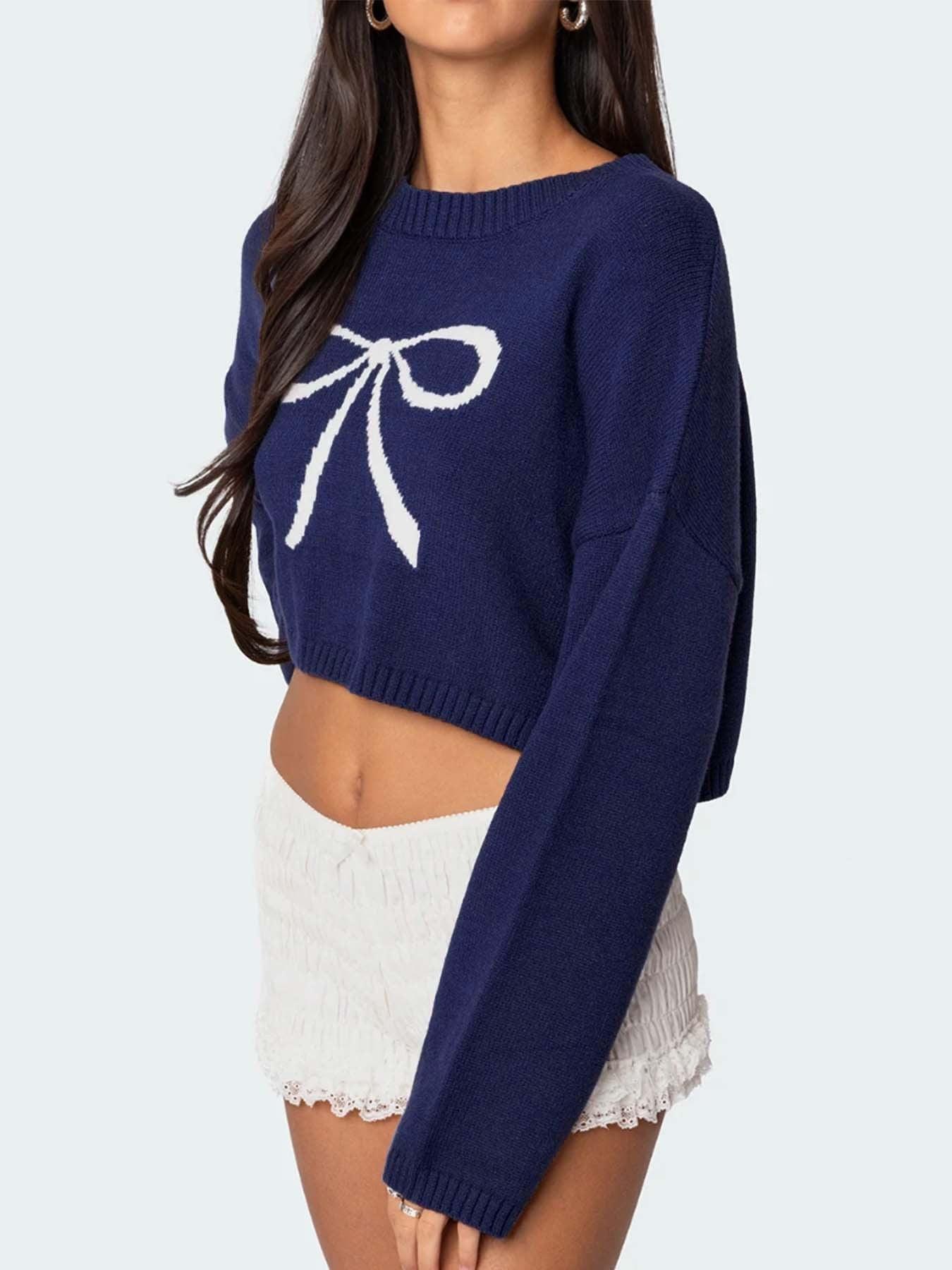 Side view of a navy blue cropped sweater with a white bow graphic.