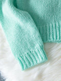 Close-up of the ribbed cuff on a mint green cardigan