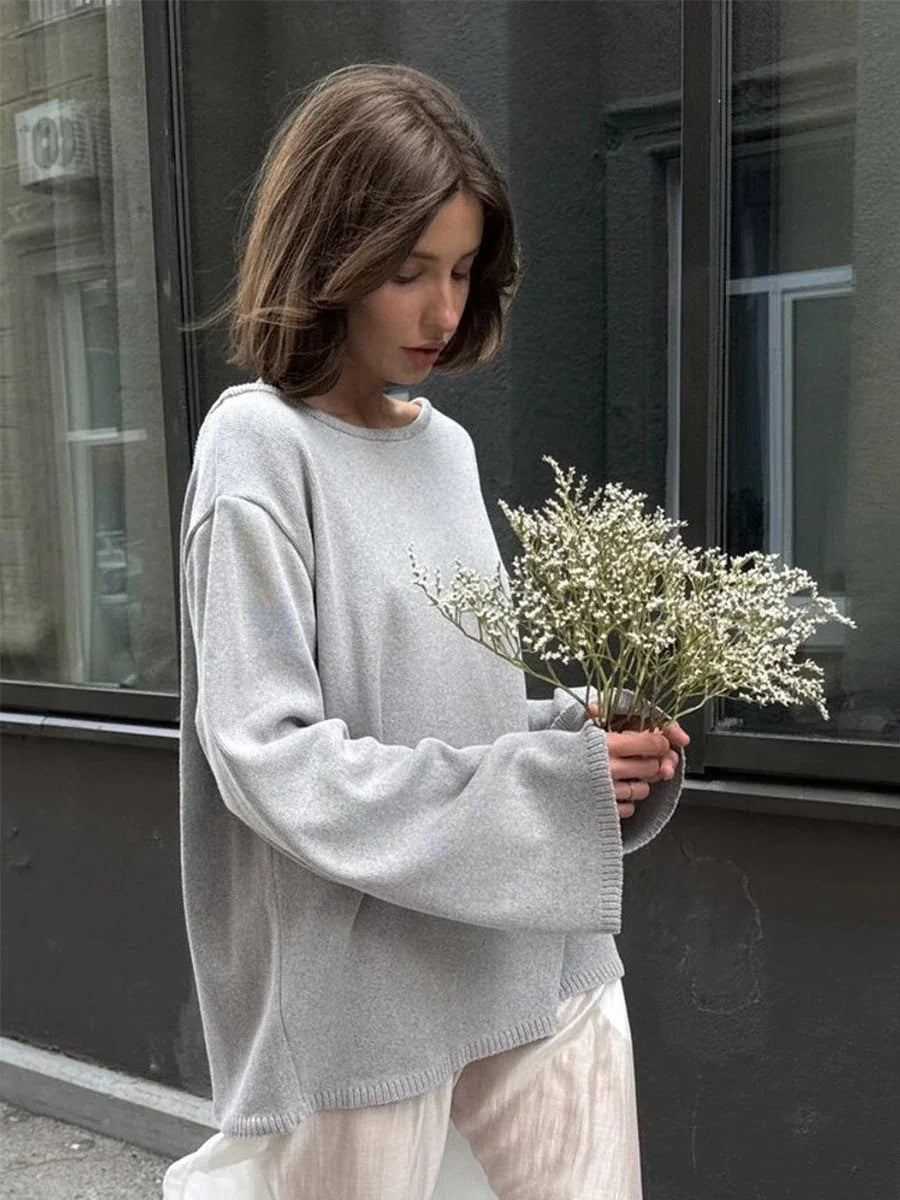 Woman wearing a light grey oversized knit sweater with bell sleeves Main image
