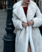 Close-up of a woman wearing a white faux fur coat, showing the lapel and sleeve detail.