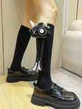 Close-up of black knee-high socks with a unique black applique attached