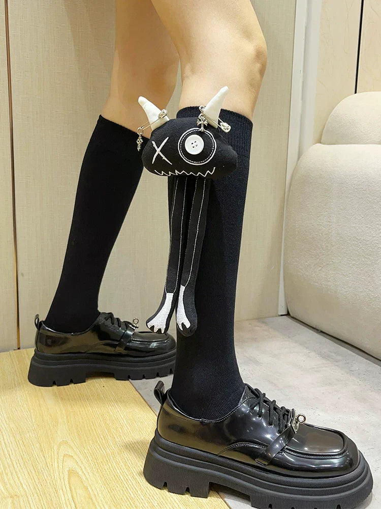 Close-up of black knee-high socks with a unique black applique attached