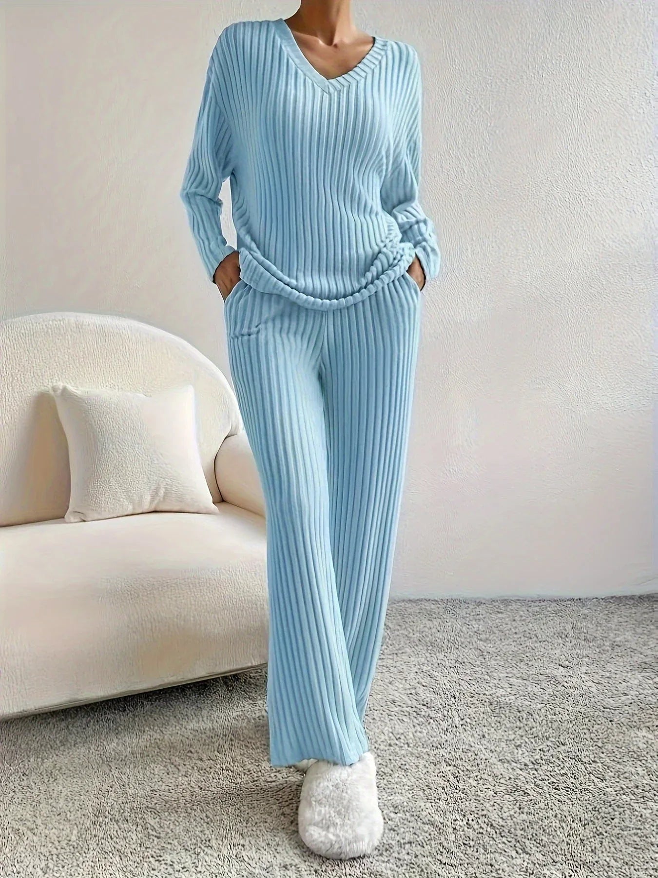 woman wearing a light blue ribbed knit lounge set with a v-neck top and wide leg pants