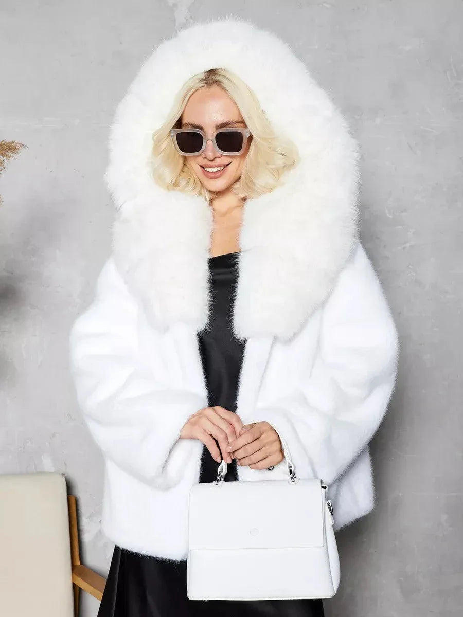 Woman in a white hooded faux fur coat and sunglasses.