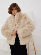 Woman wearing a beige faux fur cropped jacket with a black skirt
