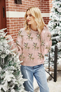 Woman wearing a pink crew neck sweater with a reindeer print