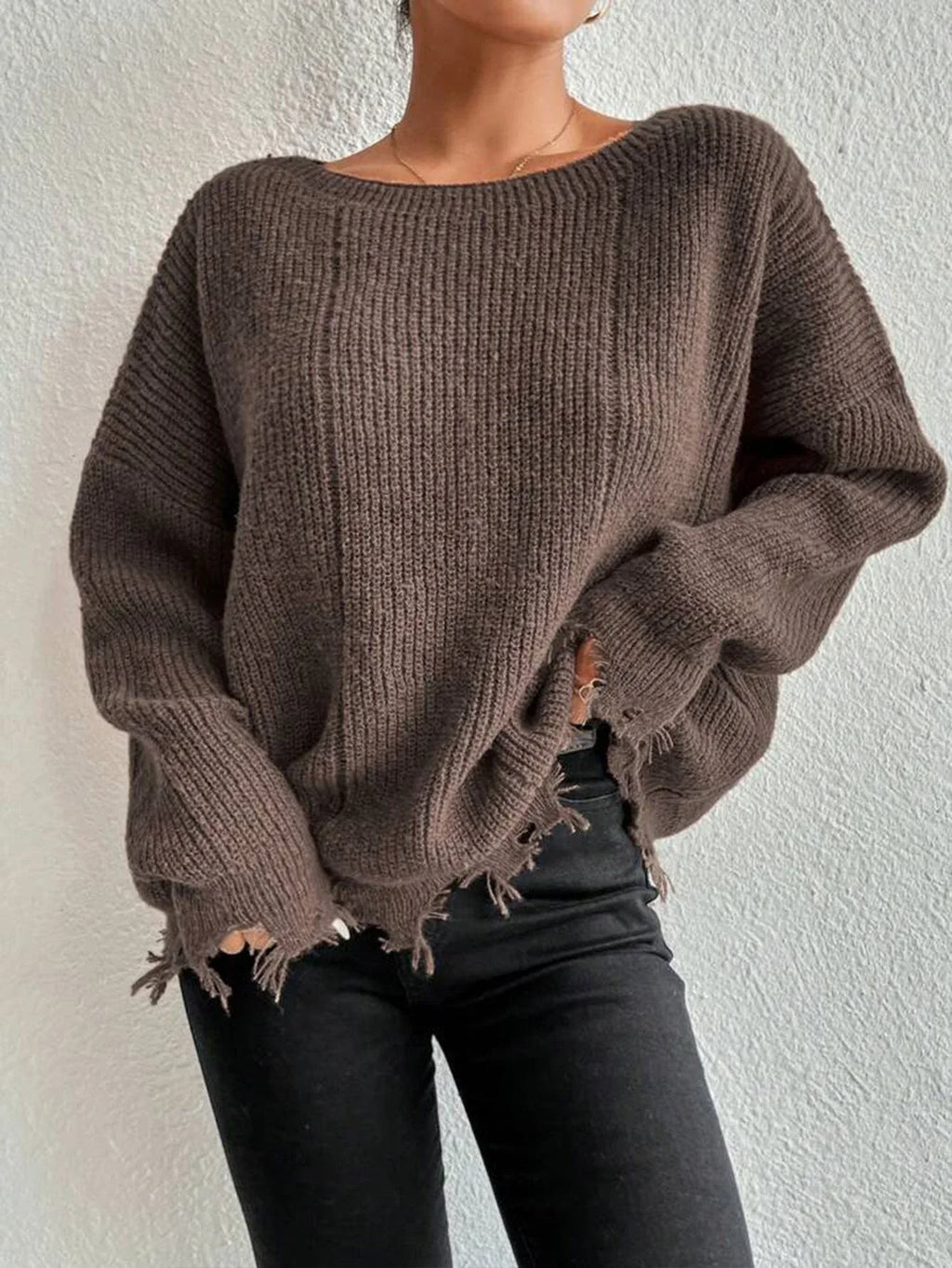 Woman wearing a brown oversized distressed knit sweater with raw hem