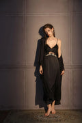 Full body shot of a woman in a black satin slip dress with lace bust detail and a matching black robe.
