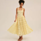 Woman wearing a yellow lace halter midi dress, twirling to show skirt