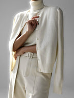 Close-up of a woman wearing a cream-colored fine knit cardigan