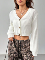 Front view of a woman wearing a white cropped cardigan with a v-neck and button-up front