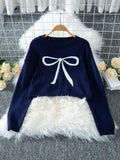 Navy blue cropped sweater with a white bow graphic, displayed on a hanger.