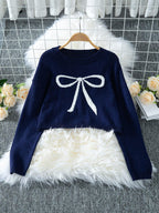 Navy blue cropped sweater with a white bow graphic, displayed on a hanger.
