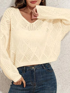 Model styling a cream V-neck pointelle knit sweater with accessories
