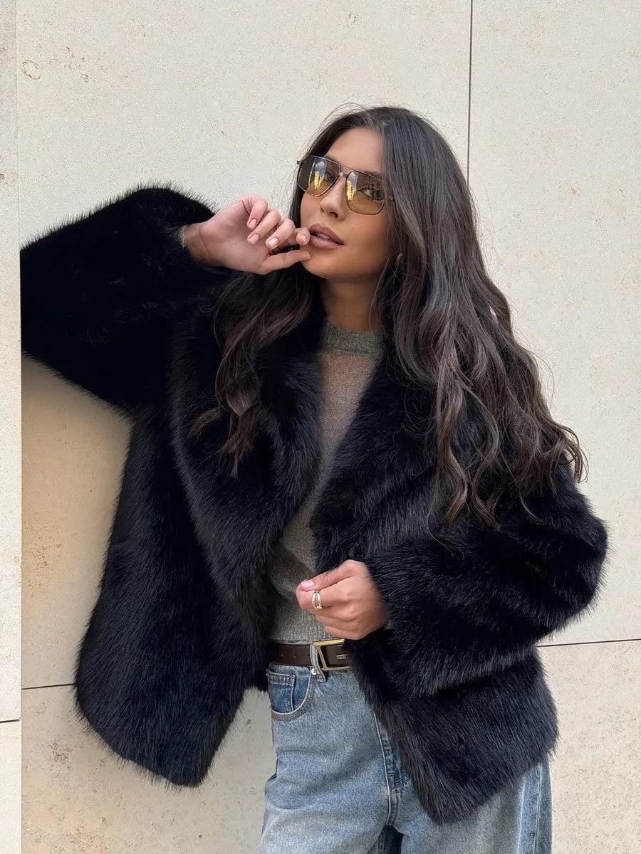 Close-up of a woman wearing a black faux fur jacket and jeans.