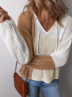 Close-up of a woman's chest and arms wearing a color block knit hoodie