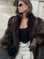 Close-up of a woman in a luxurious faux fur coat, showcasing the texture and collar.