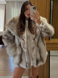 Woman wearing a grey and beige oversized faux fur jacket with a shawl collar.