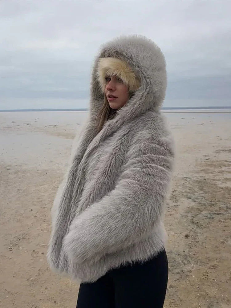 Woman with her face partially obscured by a grey hooded faux fur jacket