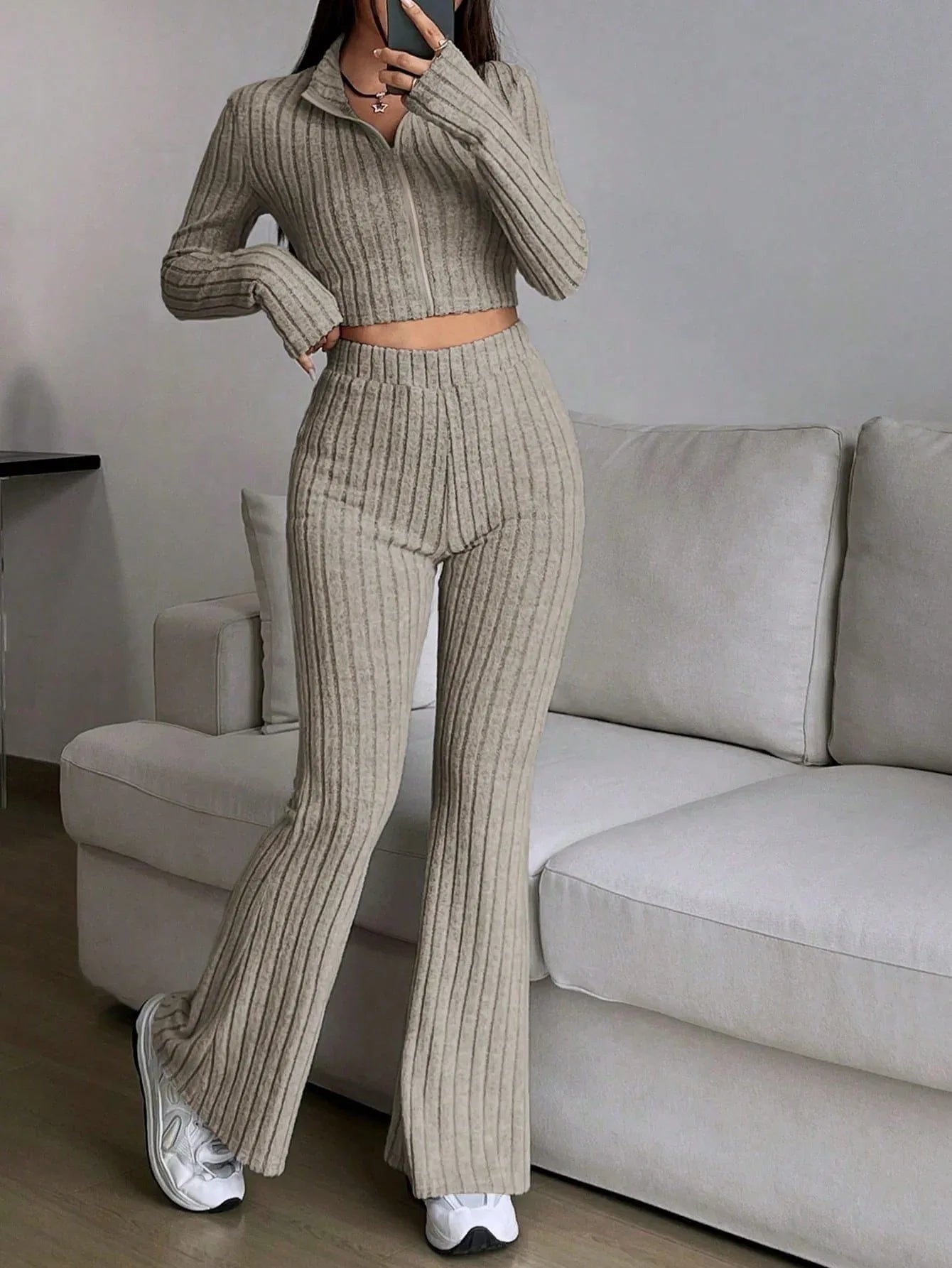 Woman wearing a beige ribbed knit cropped top and flared pants set