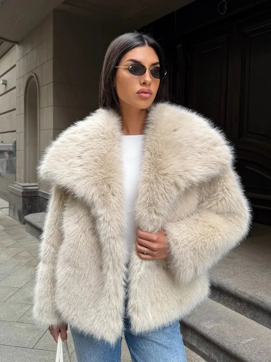 Full body shot of a woman in a cream faux fur jacket and jeans