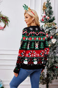 Rear view of a woman wearing a black Christmas print cardigan with long sleeves and a V-neck.