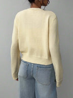 Back view of a woman in a light yellow knit cardigan.
