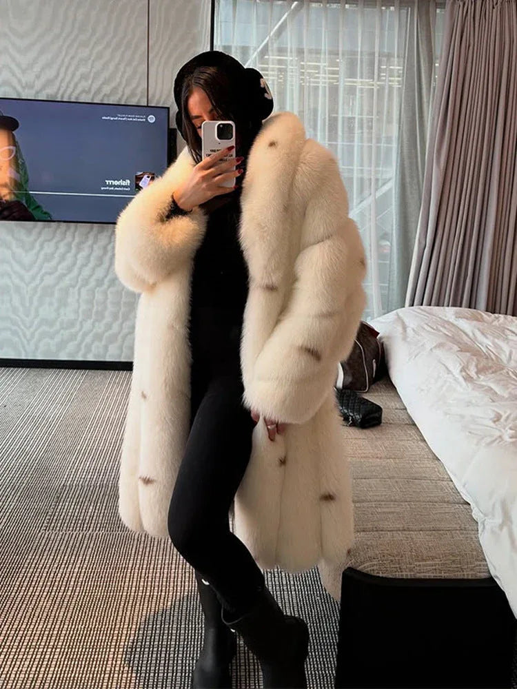 Woman wearing a long white faux fur coat indoors. Main image