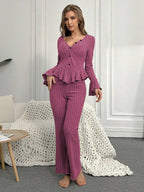 Woman wearing a purple ribbed peplum lounge set standing