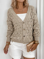Front view of a woman in a beige open-knit cardigan, showcasing the texture and buttons.